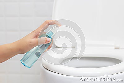 Disinfect, sanitize, hygiene care. people using alcohol spray on toilet seat lid and frequently touched area for cleaning Stock Photo