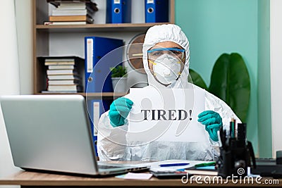 Disinfection man with special white suite working on laptop Stock Photo