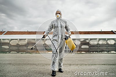 Disinfection specialist in private protective equipment PPE performing public decontamination.Hazmat suit virus protection. Stock Photo