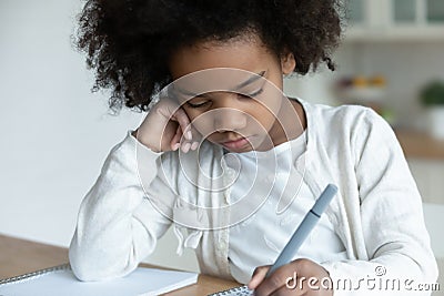 Disinterested in study african little schoolgirl do homework at home Stock Photo