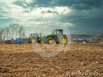 Disking soil with a tractor in Central Russia in the spring season. Editorial Stock Photo