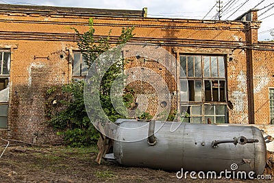 A dismantled cistern in an old abandoned factory. Dangerous place in an abandoned chemical plant Stock Photo