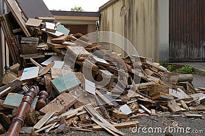Dismantled furniture on a yard between two buildings. There are pieces of wooden furniture piled up. Stock Photo