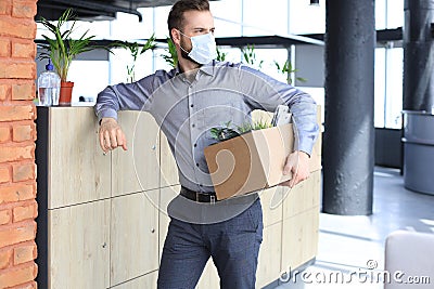 Dismissal employee in an epidemic coronavirus. Dismissed worker going from the office with his office supplies Stock Photo