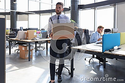 Dismissed worker going from the office with his office supplies Stock Photo