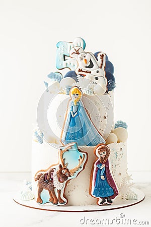 Disney character Elsa with sister Anna and her friend Olaf snowman cookies on the top of birthday cake. Frozen cartoon characters Editorial Stock Photo