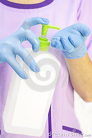 Dispenser with disinfectant. gloved hands. use of a disinfectant in medicine, Stock Photo