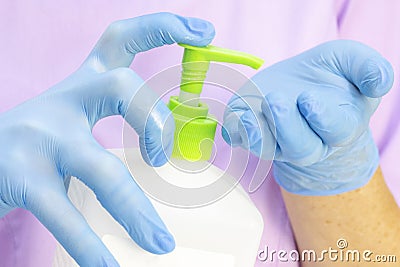 Dispenser with disinfectant. gloved hands. use of a disinfectant in medicine, Stock Photo