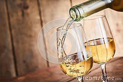 Dispensing golden white wine into two wineglasses Stock Photo