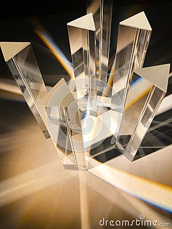 Dispersion of light through a group of triangle glass prisms. Stock Photo