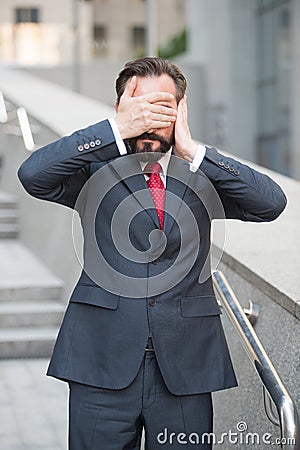 Dispirited manager standing with covered eyes and ear Stock Photo