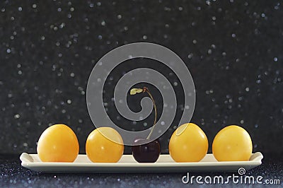 Display of prunes and cherry on a bright black bokeh background Stock Photo