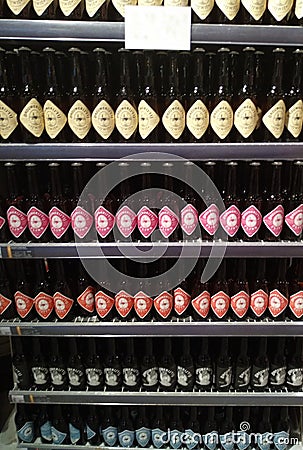 Display shelf of many Dutch craft beer bottles with colorful labels lined up Editorial Stock Photo