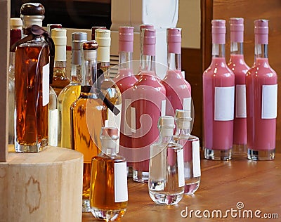 Display stand with bottle of spirits. The liqueurs have various color with blank label. Stock Photo