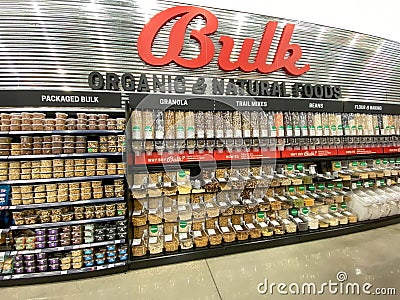 A display of a variety of bulk nuts, granola, trail mix, honey, and nut butters at a grocery store Editorial Stock Photo