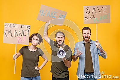 Displeased protesting young people hold protest signs broadsheet placard scream in megaphone isolated on yellow Stock Photo