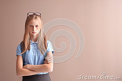 Displeased schoolgirl on color background Stock Photo