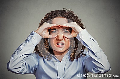 Displeased woman looking through fingers like binoculars Stock Photo