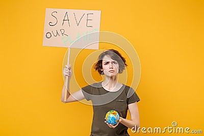 Displeased young protesting girl hold protest sign broadsheet placard on stick Earth world globe isolated on yellow Stock Photo