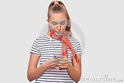 Displeased young woman using cell phone, messaging to her boyfriend. Unhappy female frowning her face and chatting with her Stock Photo