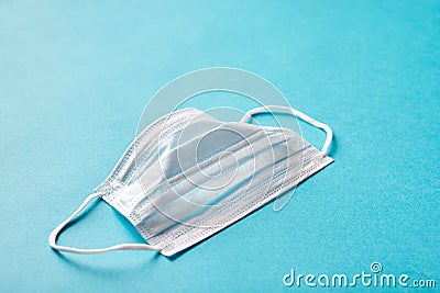 Disposable medical face mask on blue isolated background. Concept safety and health against coronavirus and over Stock Photo