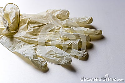 Disposable white latex gloves on white background, protective gloves during coronavirus pandemic - Image Stock Photo