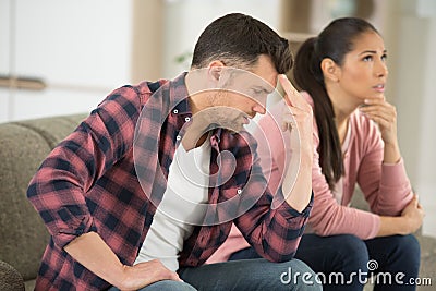 disputing couple sat on sofa Stock Photo