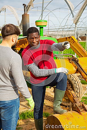 Disquieted african american gardener talking to friend Stock Photo