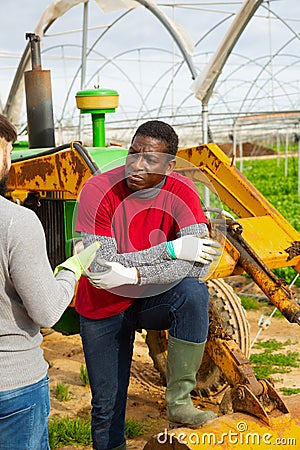 Disquieted african american gardener talking to friend Stock Photo