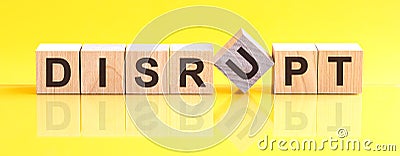 Disrupt word is made of wooden building blocks lying on the yellow table, concept Stock Photo