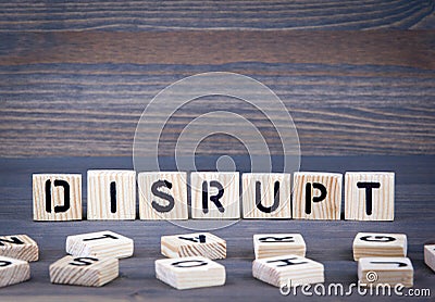 Disrupt word written on wood block. Dark wood background with texture Stock Photo