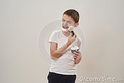 Dissatisfied boy smearing shaving foam on face Stock Photo