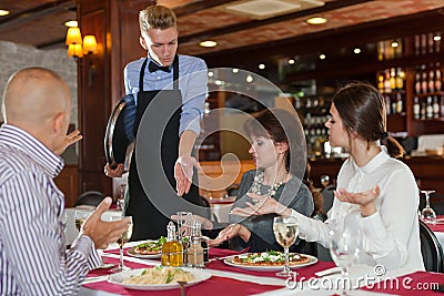 Dissatisfied guests complaining to waiter Stock Photo