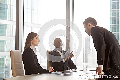 Businessman arguing with multi-ethnic partners Stock Photo