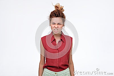 Dissatisfied young woman grimacing, clenching teeth and making angry gestur Stock Photo