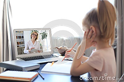 Distance learning. Cheerful little girl using laptop computer studying through online e-learning system Stock Photo