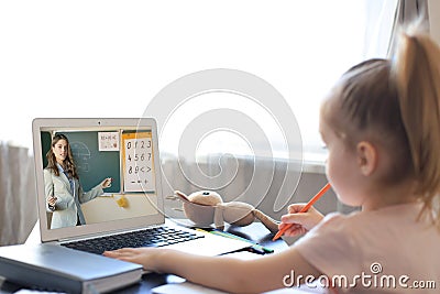 Distance learning. Cheerful little girl using laptop computer studying through online e-learning system Stock Photo
