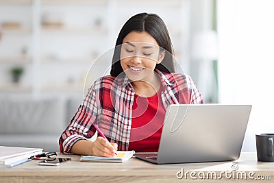 Distance Learning. Happy Asian Woman Study At Home With Laptop Stock Photo