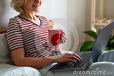 Distance learning online education and work. Cropped woman girl working office work remotely from home on bed. Using Stock Photo