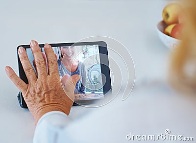 Distance makes the heart grow fonder. Rearview of a senior woman in a video converce with her grandchild. Stock Photo