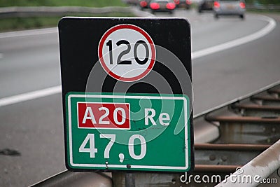 Distance sign at motorway A20 heading gouda with attention sign for speed in kilometers. Stock Photo