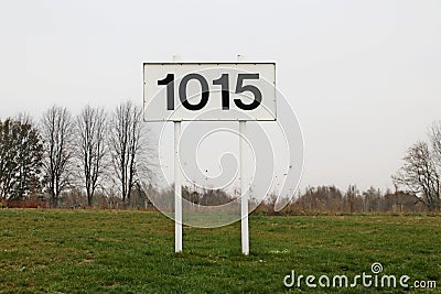 Distance sign for ships in kilometers at 1015 km on river Rhine in the Netherlands. Stock Photo