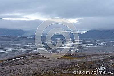 Distant Glacier Brooding in the Fog Over Its Glacial Valley Stock Photo