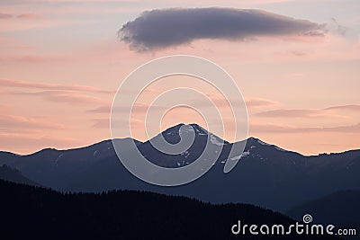 Distant hazy mountains, colored different shades of pink and grey by the setting sun Stock Photo