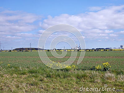 Distant power plant seen across fields Stock Photo