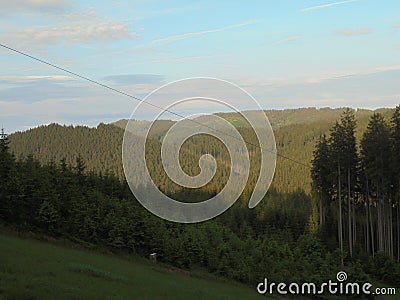 Distant landscape covered in evening sunlight. Panoramic Beskydy image. Mountain forests under blue sky Stock Photo