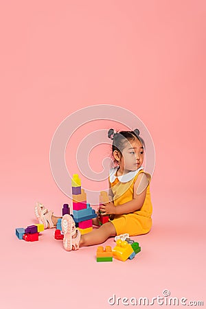 distracted asian toddler girl in yellow Stock Photo