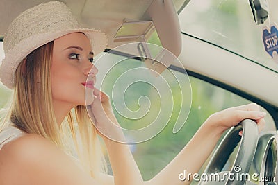 Distracted woman driving her car looking in mirror Stock Photo