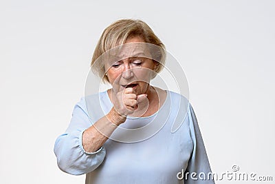 Distressed senior woman coughing Stock Photo