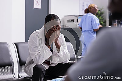 Distressed unhappy doctor sitting in clinic Stock Photo